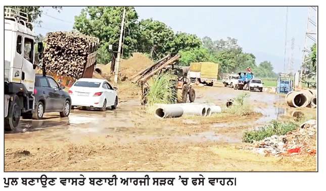  ਪੁਲ ਨਿਰਮਾਣ ਲਈ ਬਣਾਈ ਆਰਜ਼ੀ ਕੱਚੀ ਸੜਕ ’ਤੇ ਵਾਹਨ ਧੱਸਣ ਲੱਗੇ